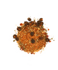 Ein kleiner Haufen der MYSPICE „Fm“-Gewürzmischung auf weißem Hintergrund, bestehend aus orange-roten gemahlenen Gewürzen, getrockneten grünen Kräutern und ganzen dunklen Pfefferkörnern oder Beeren.