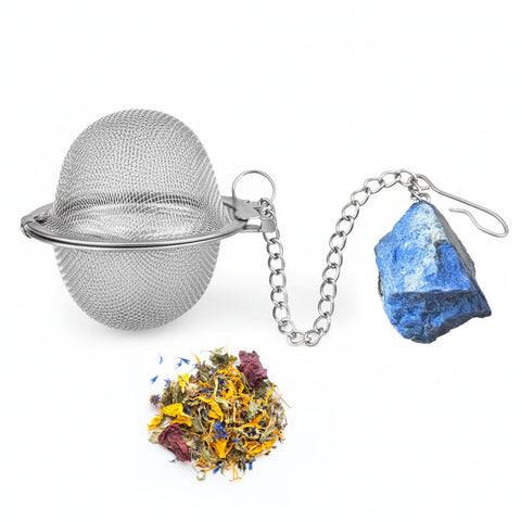 Teesieb aus Metallgeflecht mit einem Lapislazuli-Kristall und losem Kräutertee.