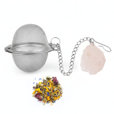 Teesieb aus Metallgeflecht mit einem Rosenquarz-Kristall und losem Kräutertee.