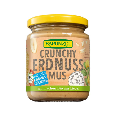 Ein Glas „Rapunzel Crunchy Erdnussmus“ mit Salz und Erdnussstückchen, abgebildet mit einem gelben Deckel und Illustrationen von Erdnüssen auf dem Etikett.