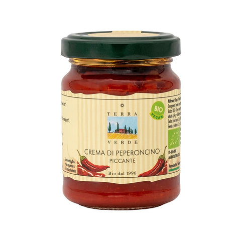 Ein Glas Terra Verde „Crema di Peperoncino Piccante“ mit grünem Deckel und einem Etikett mit roten Chilischoten.