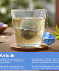 Dampfendes Glas Tee mit Metallsieb und Lapislazuli-Kristall.