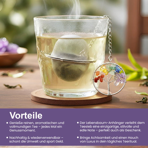 Dampfendes Glas Tee mit Metallsieb und Chakra-Lebensbaum-Anhänger.