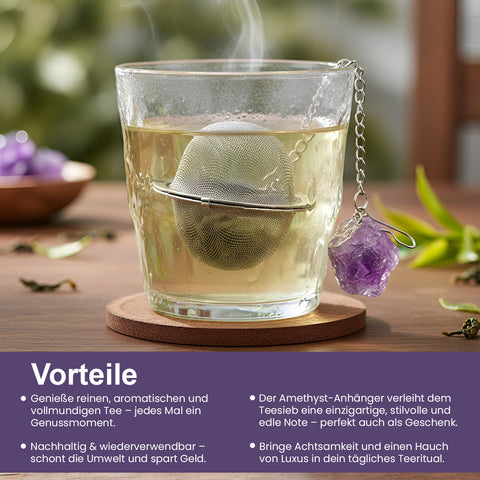 Dampfendes Glas Tee mit Metallsieb und Amethystkristall.