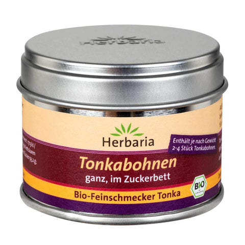 Eine geschlossene silberne Metalldose Herbaria „Tonkabohnen ganz, im Zuckerbett“ mit einem gelb-violetten Etikett und einem Bio-Siegel.