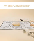 Ein bemehlter Teigballen und eine zweiseitige Teigrolle auf einer wiederverwendbaren Leckerhelfer Silikon-Backmatte, umgeben von Plätzchenausstechern. Der Text „Wiederverwendbar“ steht oben.