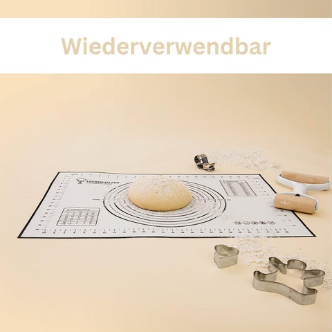 Ein bemehlter Teigballen und eine zweiseitige Teigrolle auf einer wiederverwendbaren Leckerhelfer Silikon-Backmatte, umgeben von Plätzchenausstechern. Der Text „Wiederverwendbar“ steht oben.