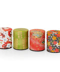 Eine Reihe von vier kleinen japanischen Teedosen (Natsume), verpackt in buntes, gemustertes Papier.