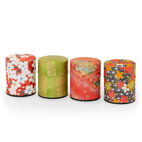 Eine Reihe von vier kleinen japanischen Teedosen (Natsume), verpackt in buntes, gemustertes Papier.