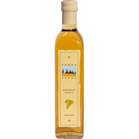 Eine klare Glasflasche Terra Verde Balsamico Bianco (weiße Balsamico-Würze), mit einem hellgelben Etikett, das eine Illustration eines Bauernhofs und weißer Trauben zeigt.