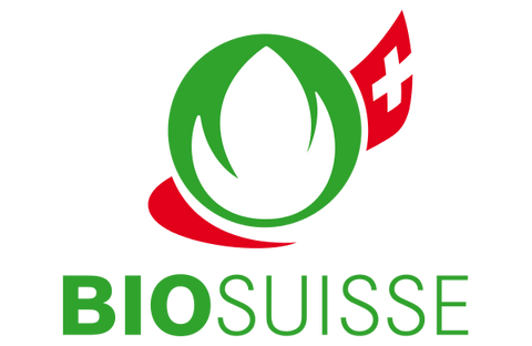 Das offizielle Bio Suisse Logo mit einer stilisierten grünen blattförmigen Knospe in einem Kreis und einem rot-weißen Schweizer Flaggenelement auf der rechten Seite.