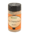 Ein transparentes Gewürzglas mit schwarzem Deckel, gefüllt mit „Dip Chimichurri Bizarro“ Gewürzmischung von Gwürzhüsli, mit einem orange-cremefarbenen Etikett.