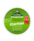 Rundes Etikett des Schmelzkäse-Produkts "Glarissa" von Glarner Schabziger, beworben als Kalziumquelle. Es zeigt ein Logo der Schweizer Berge und das ESAF 2025 Munipartner-Logo.