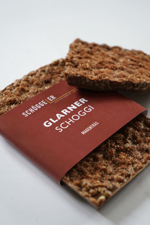 Texturierte Schokolade mit einer rotbraunen Banderole mit der Aufschrift „Glarner Schoggi“.