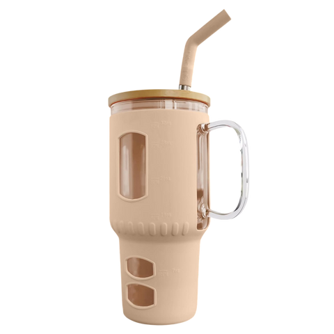 Ein großer Glasbecher in Beige mit einer isolierenden Silikonhülle, einem Henkel, einem Strohhalm und aufgedruckten Füllstandsmarkierungen in Unzen und Millilitern.