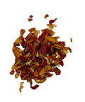 Ein Haufen getrockneter, grob geschnittener orange-roter Hagebuttenschalen mit einigen sichtbaren kleinen, hellen Samen, verteilt auf einem schlichten weißen Hintergrund.