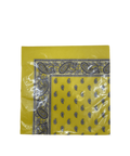 Eine eingeschweißte Packung leuchtend gelber Papierservietten mit einer schwarz-weißen Paisley-Bordüre und einem passenden Tropfenmuster in der Mitte.