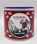 Eine große Gewürzdose mit blauem Deckel und rotem Etikett für „Glühwein Gewürzmischung“, dekoriert mit Zeichnungen von Zimt und Glühwein.