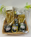 Als Geschenk verpackter Korb mit Grissini, Likör, Pasta und drei Gewürzdosen.