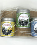 Drei etikettierte Gewürzdosen auf einem kleinen Holzbrett, in Klarsichtfolie verpackt mit Schleife und Schmetterlingsdeko.