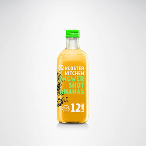 Große Flasche mit gelbem Ingwer- und Ananas-Shot und grünem Deckel.