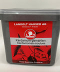 Eine graue Kunststoffdose der Landolt Hauser AG mit rotem Etikett für gemahlenen Kardamom („Kardamom gemahlen / Cardamomes moulues“).