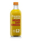 Eine klare Glasflasche „Kloster Kitchen Ingwer Shot Kurkuma“ mit einer leuchtend gelben Flüssigkeit, einem orangefarbenen Deckel, einem Bio-Siegel und der Aufschrift „12 SHOTS“.