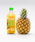 Eine große Flasche Ananas-Ingwer-Shot steht neben einer ganzen Ananas.