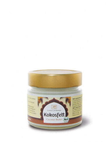 Ein kleines Glas „Kokosfett“ (Coconut Butter) von Classic Ayurveda mit goldfarbenem Deckel und einem Etikett, das Palmenmotive sowie ein grünes Bio-Siegel zeigt.