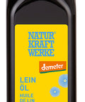 Eine dunkle Glasflasche "Lein Öl" von Natur Kraftwerke mit einem leuchtend gelben Etikett, blauen Leinsamenblüten und dem Demeter-Bio-Siegel.