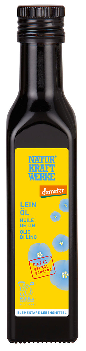 Eine dunkle Glasflasche "Lein Öl" von Natur Kraftwerke mit einem leuchtend gelben Etikett, blauen Leinsamenblüten und dem Demeter-Bio-Siegel.