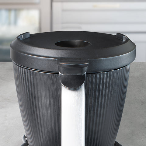 Nahaufnahme eines schwarzen, strukturierten Mixbehälters mit silbernem Griff und schwarzem Deckel.