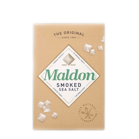 Eine braune Kartonverpackung für „Maldon Smoked Sea Salt“ (geräuchertes Meersalz) mit einem weißen rautenförmigen Logo, grüner Schrift und Illustrationen von pyramidenförmigen Salzkristallen.