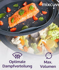 Gedämpftes Gemüse unten und Lachs auf dem Tablett oben, der Dampfkamin in Gebrauch.