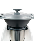 Grauer und durchscheinender mixcover Thermo-Griff Deckelhalter auf dem Mixtopf eines weißen Küchengeräts (vermutlich Thermomix).