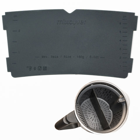 Der dunkelgraue mixcover Silikon „Garkorb-Teiler“ neben dem Thermomix Mixtopf, in den der Teiler in den Garkorb eingesetzt ist. Markierungen zeigen die maximale Reiskapazität (150 g / 5.3 oz).