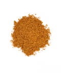 Eine Nahaufnahme von fein gemahlenem, orange-braunem Nasi Goreng Gewürz, das als kleiner Haufen auf einem weißen Hintergrund liegt.