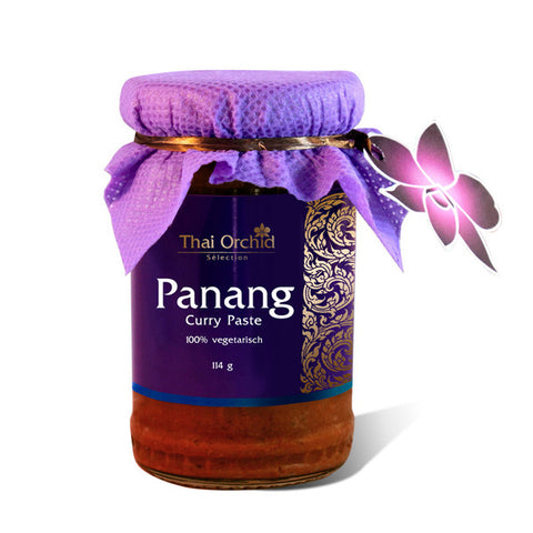 Ein Glas Thai Orchid Selection Panang Curry Paste (114g), als 100 % vegetarisch gekennzeichnet, mit einem lila Etikett, einer Stoffkappe und einem Schmetterlingsanhänger.