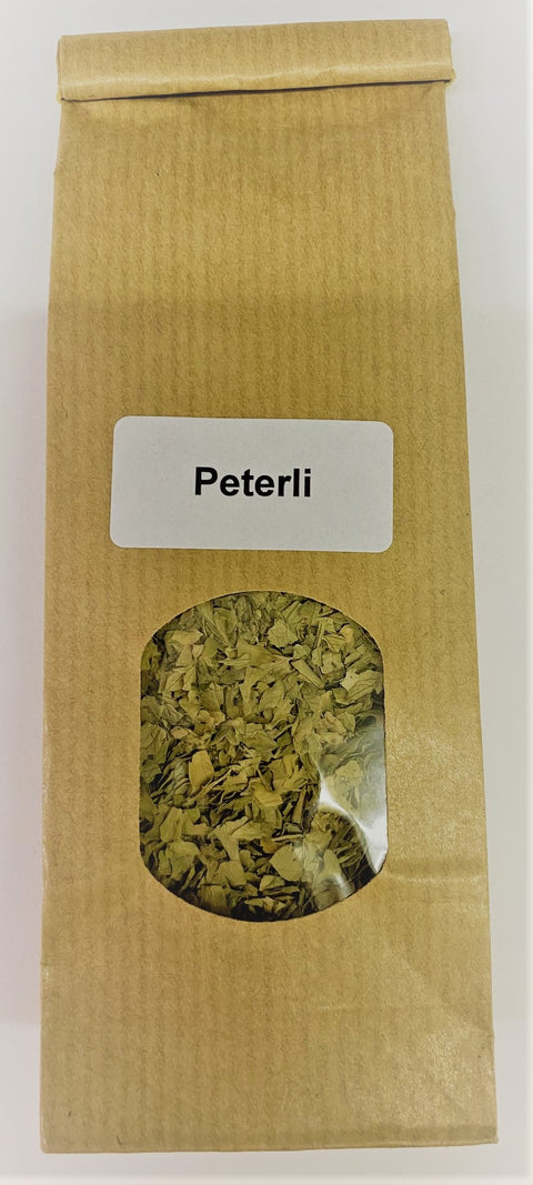 Eine braune Papiertüte mit einem kleinen Sichtfenster, das getrocknete grüne Petersilienflocken zeigt, beschriftet mit einem weißen Etikett „Peterli“.