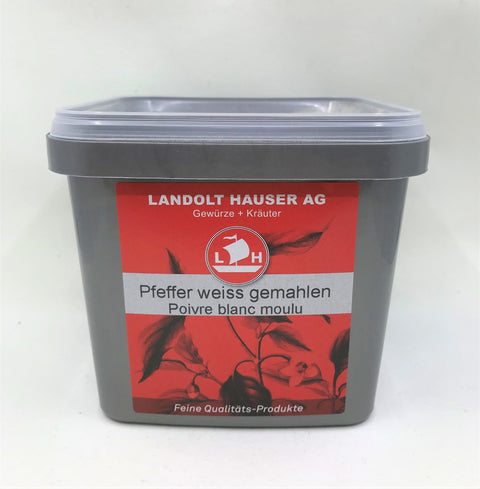 Ein quadratischer grauer Kunststoffbehälter mit „Pfeffer weiss gemahlen“ von Landolt Hauser AG, mit einem roten Etikett, Segelschiff-Logo und botanischen Illustrationen.
