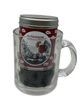 Eine rote Glühwein Gewürzdose in einem durchsichtigen Glasbecher mit Paisley-Muster.