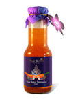 Eine Glasflasche Thai Orchid Selection Thai Spicy Salatsauce, als Vegan gekennzeichnet, mit einem lila Etikett mit einem Riesen, der eine Chili hält, einer lila Stoffkappe und einem Orchideenanhänger.