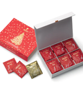 Ein festlicher Sirocco Tee-Adventskalender mit einer roten Außenverpackung samt goldenem Weihnachtsbaum und einer weißen Innenbox, die nummerierte rote und goldene Teebeutel enthält.