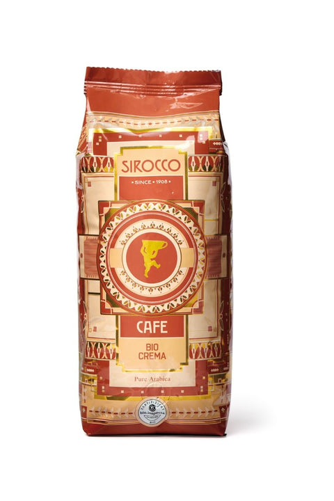 Eine orangerote Kaffeepackung von „Sirocco Cafe Bio Crema Pure Arabica“ mit goldenem Art-déco-Muster und einem „bio.inspecta“-Bio-Zertifizierungssiegel am unteren Rand.