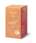 Eine orangefarbene Kartonverpackung für Sirocco „Camomile Orange Blossoms“ Bio-Kräutertee, verziert mit eleganten weißen Ornamenten und einer Seitenwand mit der mehrsprachigen Zutatenliste.