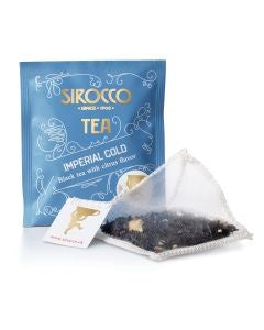 Ein blaues Tee-Sachet für Sirocco „Imperial Gold“ (Schwarztee mit Zitrusaroma) neben einem transparenten Pyramidenteebeutel, der mit losem schwarzem Tee und Zitusschalen gefüllt ist.