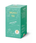 Eine smaragdgrüne Kartonverpackung für Sirocco „Jade Oolong“ Bio-Grüntee, verziert mit weißen Ornamenten und einer Seitenwand mit mehrsprachigen Produktinformationen.
