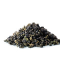 Ein kleiner Haufen loser Sirocco „Jade Oolong“-Tee auf weißem Hintergrund mit großen, dunkelgrünen Bio-Teeblättern, die fest gerollt und teilfermentiert sind.