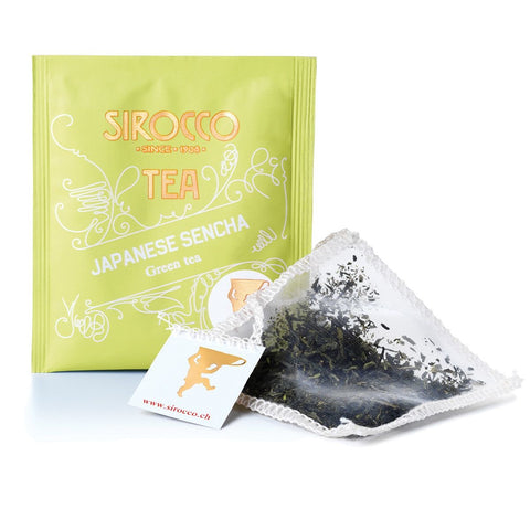 Ein hellgrünes Sachet Sirocco „Japanese Sencha“ neben einem pyramidenförmigen Teebeutel mit losen Teeblättern.