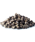 Ein kleiner Haufen loser Sirocco „Jasmine Dragon Pearls“ Grüntee auf weißem Hintergrund mit handgerollten, kugelförmigen Teeblättern in Silber- und Dunkelgrüntönen.